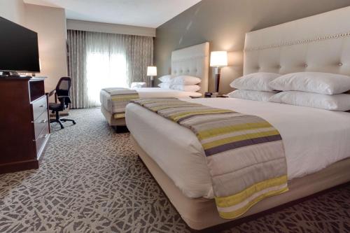 亨茨维尔Drury Inn & Suites Huntsville Space & Rocket Center的酒店客房设有两张床和电视。