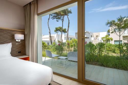 胡塞马Radisson Blu Resort Al Hoceima的一间卧室设有一张床和一个滑动玻璃门