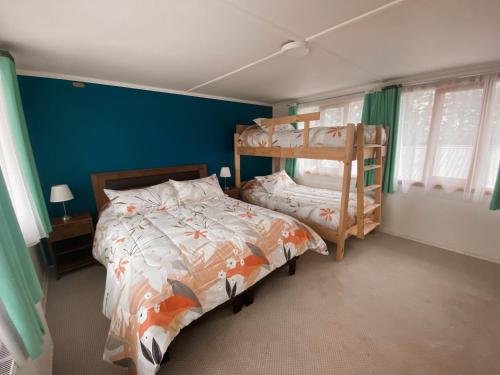 蓬塔阿雷纳斯Indomito Sur Hostel的一间卧室设有两张双层床和蓝色的墙壁
