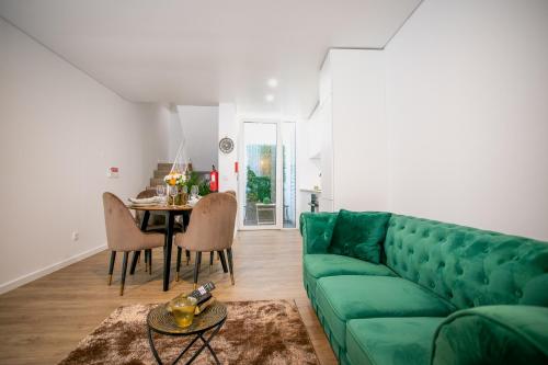 蓬塔德尔加达City Glow House的客厅配有绿色沙发和桌子