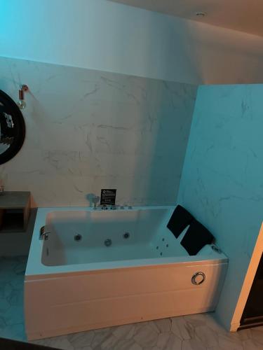 特雷武Love room borabora 3的蓝色天花板的客房内设有浴缸