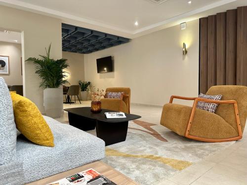 达喀尔Hôtel AL AFIFA的客厅配有沙发、椅子和桌子