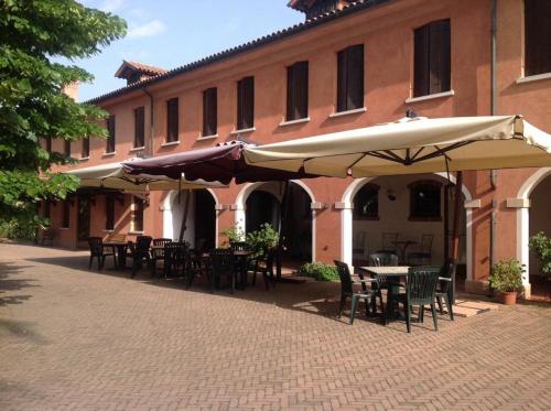 特雷维索达尼诺提农家乐的大楼前带桌子和遮阳伞的天井