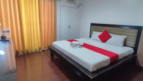 马尼拉Poblacion Bed & Breakfast by SMS Hospitality的一间卧室配有红色和白色枕头的床