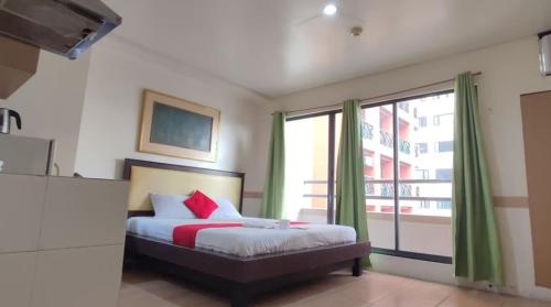 马尼拉Poblacion Bed & Breakfast by SMS Hospitality的一间卧室设有一张床和一个大窗户