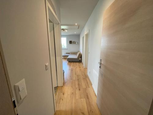 施韦夏特Cozy Apartment near Vienna Airport的走廊通往带床和门的房间