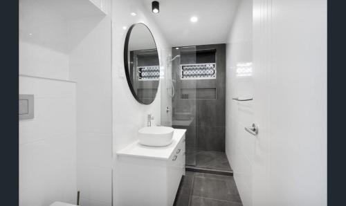 邦加里Bribie Waters Apartment的白色的浴室设有水槽和镜子