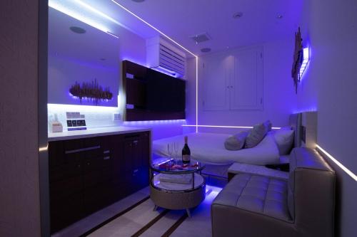 东京Hotel Blanche 大人専用的客厅配有白色沙发和紫色照明