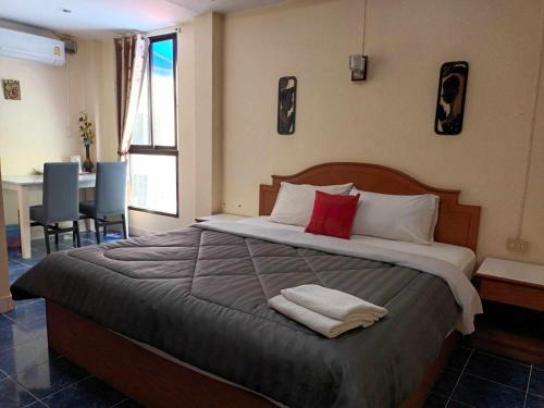 芭东海滩芭东玫瑰宾馆的一间卧室配有一张大床和两条毛巾
