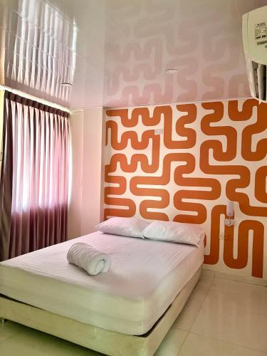 BaranoaHotel Paranawa的一间卧室配有一张带橙色和白色床头板的床