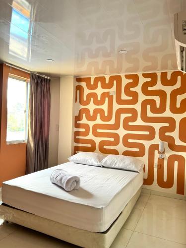 BaranoaHotel Paranawa的一间卧室配有一张橙色墙壁的床