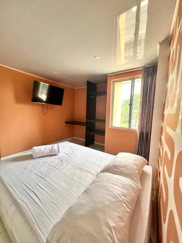 BaranoaHotel Paranawa的卧室配有白色的床和窗户。