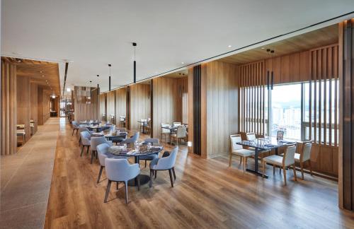大田城际酒店的餐厅设有桌椅和大窗户。