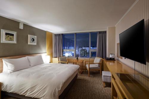 大田城际酒店的酒店客房配有一张床和一张书桌及一台电视