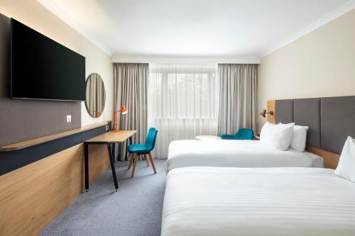 霍利假日伦敦盖特威克机场酒店的配有两张床铺的酒店客房,设有一张桌子和一台电视机