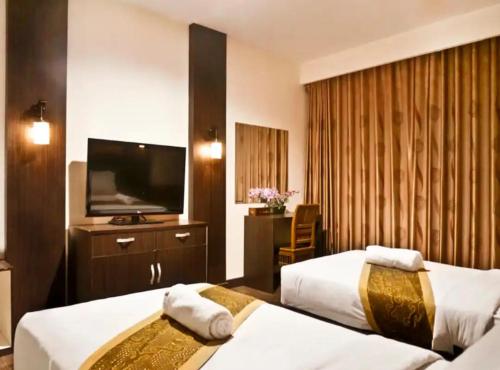 北干巴鲁STEFANI MAKATI HOTEL的酒店客房设有两张床和一台平面电视。