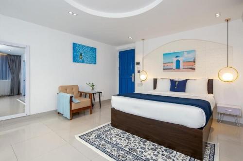岘港Lucia Beach Hotel的一间卧室配有一张床、一把椅子和一张桌子