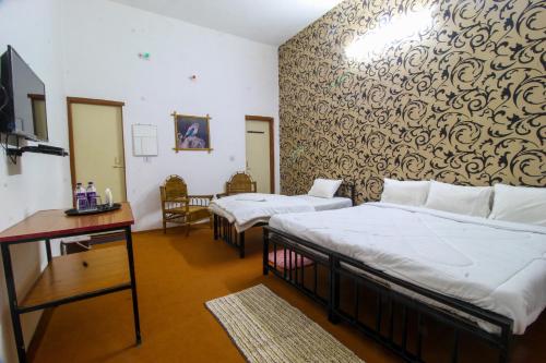 DhanwārSaalwood Safari Lodge的一间酒店客房,设有两张床和电视