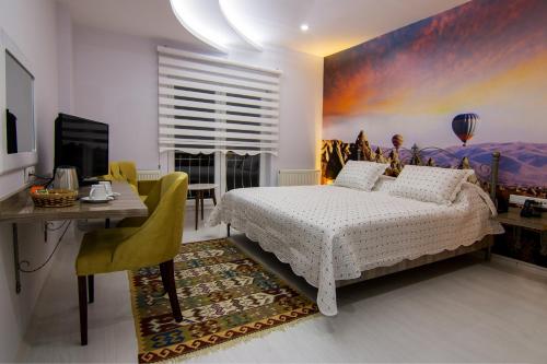 乌奇希萨尔Cappadocia Symbol Hotel的一间卧室配有一张床、一张桌子和一张书桌