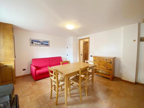 尚波吕克The Snow - Appartamento Panoramico con Balcone的客厅配有桌子和红色沙发