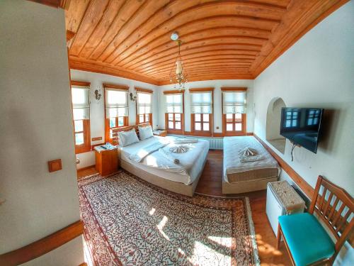 番红花城Muhsin Bey Konağı的一间大卧室,配有一张大床和一台平面电视