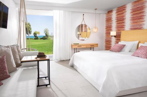阿默达拉-伊拉克利翁阿加比海滩高级全包度假村的卧室设有一张白色大床和一扇窗户。
