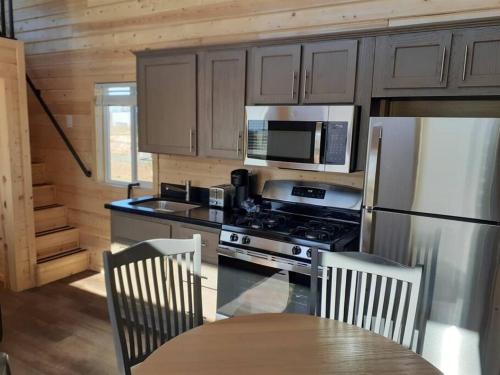 瓦莱065 Star Gazing Tiny Home nr Grand Canyon South Rim Sleeps 8的厨房配有炉灶、冰箱和桌子