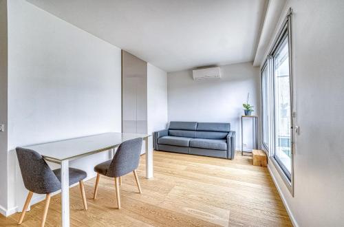 布洛涅-比扬古Superbe 2 pièces 52 m2 refait à neuf Boulogne Nord - Superb brand new 1 bedroom appartement North of Boulogne的配有桌子、两把椅子和一张沙发的房间