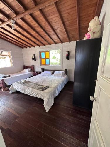 San VicenteEL PARAISO G - FINCA HOTEL LGBT - ADULTS ONLY的一间带一张床的卧室,位于带木制天花板的房间内
