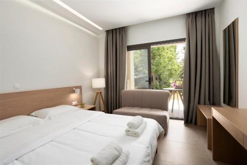 埃帕诺米Akti Retzika的酒店的客房 - 带一张床、椅子和窗户