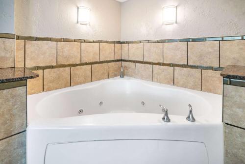 西大西洋城华美达酒店的浴室设有浴缸和2个水龙头