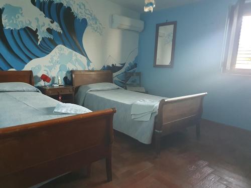 Montecorvino PuglianoAl Rifugio的一间卧室设有两张床和蓝色的墙壁