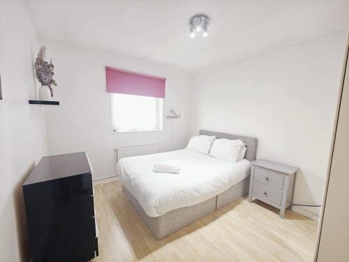 伦敦City Airport Apartment的白色的卧室设有床和窗户