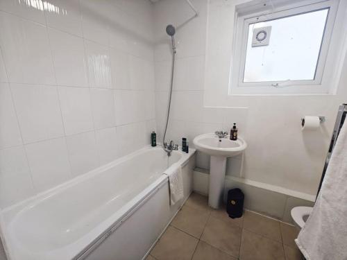 伦敦City Airport Apartment的白色的浴室设有水槽、浴缸和水槽。