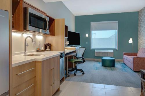 拉斯维加斯Home2 Suites By Hilton Las Vegas North的一个带水槽的厨房和一张书桌