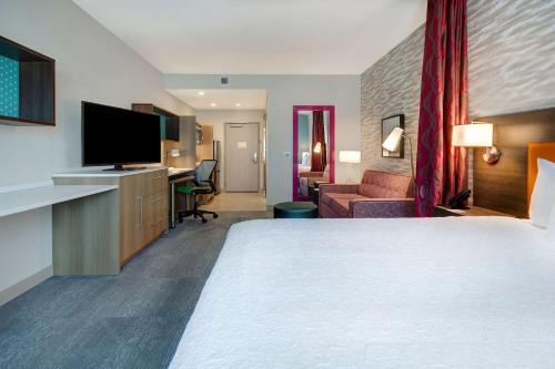 拉斯维加斯Home2 Suites By Hilton Las Vegas North的一间酒店客房,配有一张大床和一台平面电视