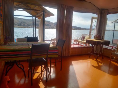 普诺Uros Titicaca Ayni lodge的一间配备有桌子的用餐室,享有水景