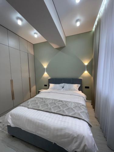 比什凯克Rent Apartment的一间卧室配有一张大床和灯光