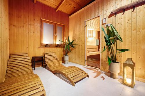 KonopnicaResort Zacisze Apartamenty的一间设有木墙和木凳的桑拿浴室