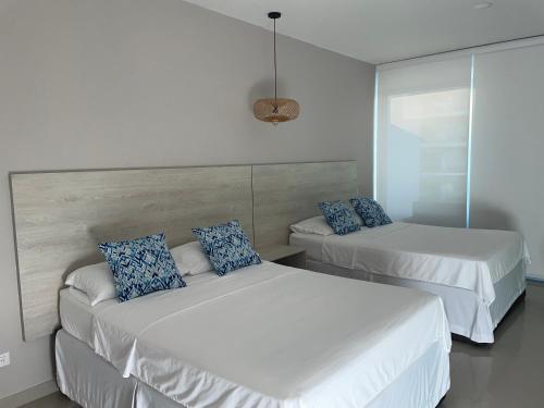 卡塔赫纳Apartamento de lujo Morros ULTRA con vista y acceso directo al mar , Cartagena de Indias的卧室内的两张床和蓝色枕头