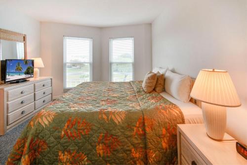 圣徒皮特海滩Amadeus 6的一间卧室配有一张床和一个带灯的梳妆台