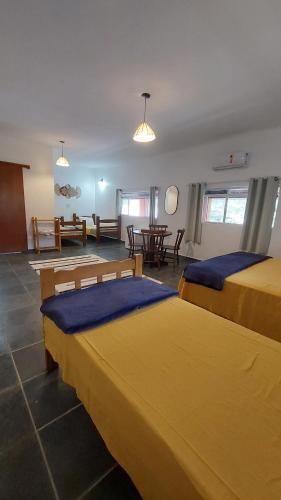 圣塞巴斯蒂安Pousada Sol do Araçá的酒店客房设有两张床和一张桌子。