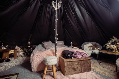 Glamping in - luxury tent的帐篷内一间卧室,配有一张床