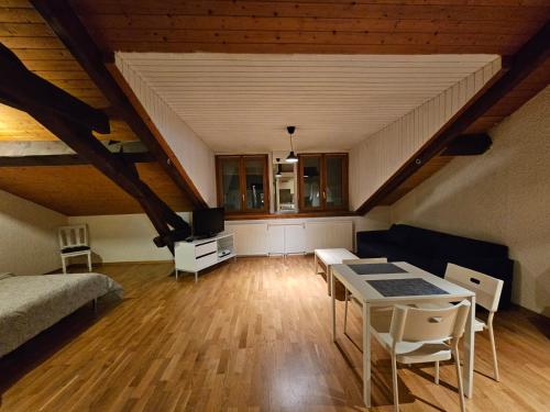 日内瓦Studio au centre de Genève的阁楼间配有床、桌子和椅子
