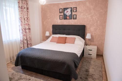 皮亚特拉-尼亚姆茨Urban Oasis的一间卧室配有一张大床和黑色床头板