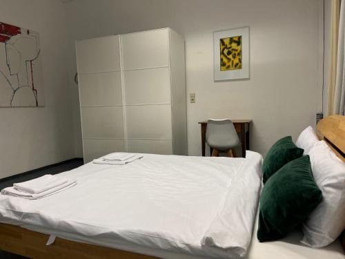 瓦尔茨胡特田根Waldshut Stadt Ferien Wohnung的卧室配有带绿色枕头的白色床