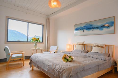凤凰云起山居庭院观景民宿的一间卧室配有一张带鲜花的大床