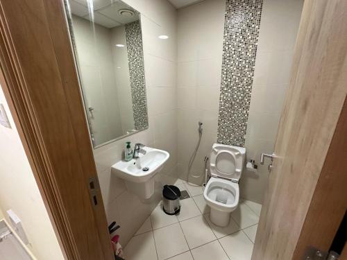 迪拜Continental Tower - Vigor Vacation Homes的一间带水槽、卫生间和镜子的浴室