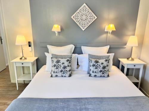罗卡马杜尔Hôtel Les Vieilles Tours Rocamadour的卧室配有白色的床、枕头和2张桌子