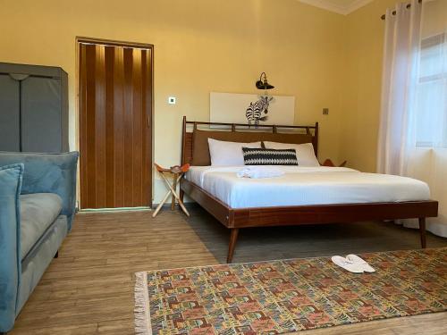 NarokEmirishoi Cottages and Garden Bistro的一间卧室配有一张大床和一张沙发